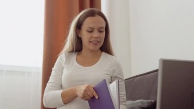 Hamile, açık tenli bir kadın bir bilgisayardaki video bağlantısı ile doktorla iletişim kuruyor.