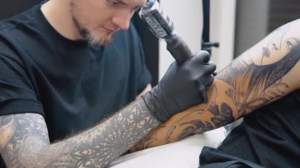 Il processo di tatuare una mano di un uomo in un salone di tatuaggi. Tatuaggio professionale nel rispetto delle norme di sicurezza sanitaria — Video Stock