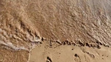 The inscription chill in the sand is washed away by the waves