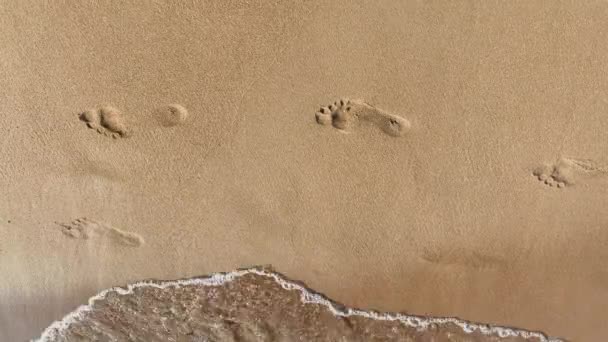 Footprints in the sand washed away by the sea waves — Video Stock