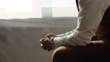 Successful young man in brown business suit and tie sits near the window in his office