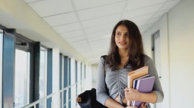 Pakistani woman student with a books in the university. New modern fully functional education facility. Education abroad