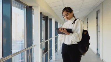Pakistani woman student with a tablet in the university. New modern fully functional education facility. Education abroad