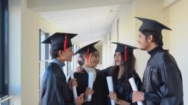 A group of Indian students with diplomas communicate in the university building