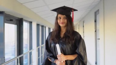 Indian female graduate in black gown and wearing masters hat in university. An important event. Young specialist