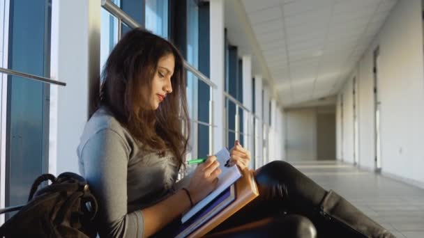 Indian girl student sitting on the floor with a books in the university. New modern fully functional education facility. Education abroad — Stockvideo