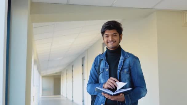 Estudiante indio con libros en la universidad o la universidad. Nueva instalación educativa moderna totalmente funcional. Educación en el extranjero — Vídeos de Stock