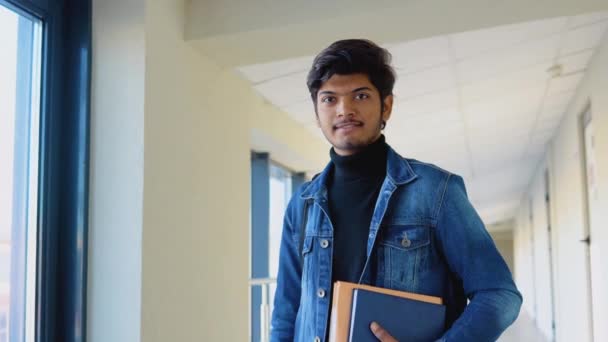 Estudiante indio con libros en la universidad. Nueva instalación educativa moderna totalmente funcional. Concepto educativo — Vídeo de stock