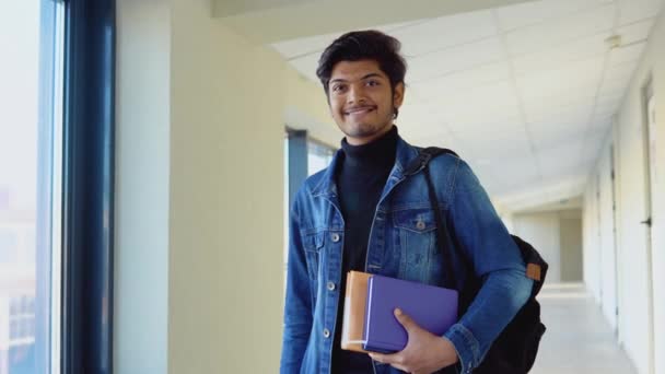 Estudiante indio con libros en la universidad. Nueva instalación educativa moderna totalmente funcional. Concepto educativo — Vídeos de Stock