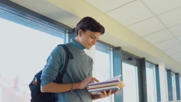 Pakistani student with a books in the university. New modern fully functional education facility. Education abroad — Vídeos de Stock