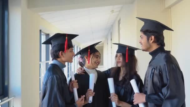 A group of Indian students with diplomas communicate in the university building — Vídeo de Stock