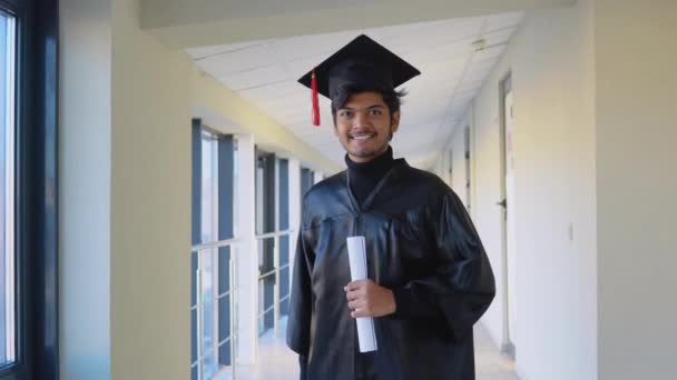 Indian graduate in mantle stands with a diploma in her hands and smiles. An important event. Young specialist — Stock video