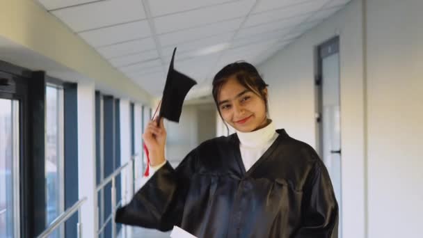 Indian female graduate in black gown and wearing masters hat in university. An important event. Young specialist — Stockvideo