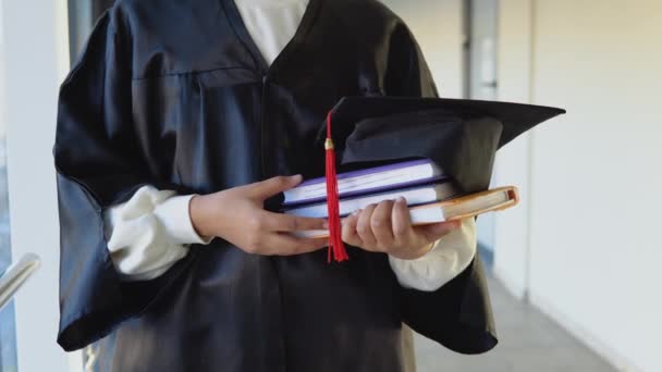 Indian female graduate in mantle stands with a books in her hands. Closeup — Stock video