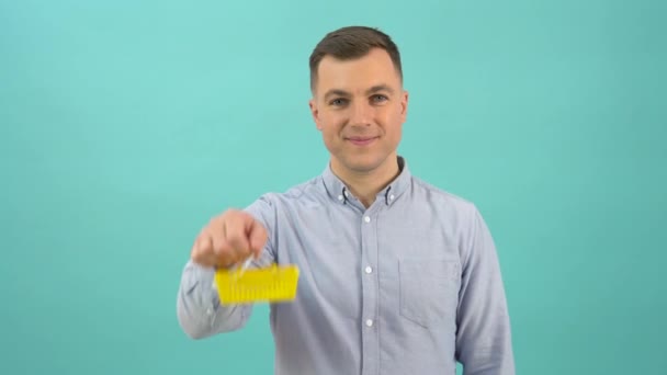 Un hombre caucásico positivo feliz en una camisa azul muestra felizmente una cesta de la compra del juguete en sus manos — Vídeo de stock