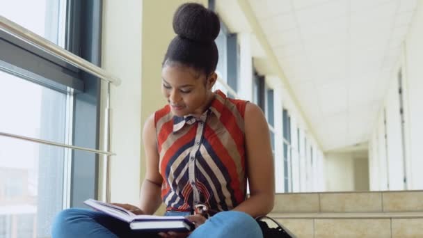 Afro-Amerikaanse studente met boeken op de universiteit. Onderwijsconcept — Stockvideo