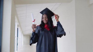 Afrika kökenli Amerikalı kadın, elinde diplomayla ve gülümseyerek mezun oluyor. IT Üniversitesi 'nden diplomayla mezun olmuş.