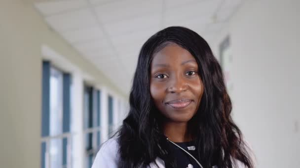 Porträt einer afrikanisch-amerikanischen Ärztin oder Internistin, die mit Stethoskop in der Klinik vor der Kamera posiert — Stockvideo