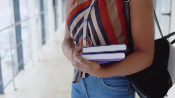 O studentă afro-americană stă cu o carte în mână. Closeup — Videoclip de stoc