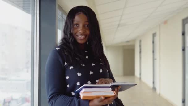 Afrykańska amerykańska studentka z książkami na uniwersytecie. Koncepcja edukacji — Wideo stockowe
