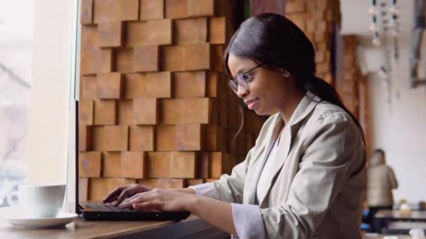 Jovem árabe mulher usando computador portátil no café. Profissional do sexo feminino trabalhando com notebook — Vídeo de Stock