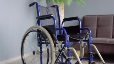 Koltuğun yanındaki parlak odada tekerlekli sandalye. Engellilik ve hareketlilik kavramı