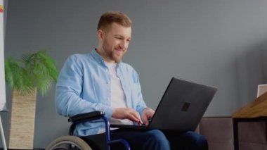 Özürlü serbest çalışan biri, ofiste tekerlekli sandalyede oturan dizüstü bilgisayarlı daktiloyla çalışıyor. Uzak çalışma ve engellilik kavramı