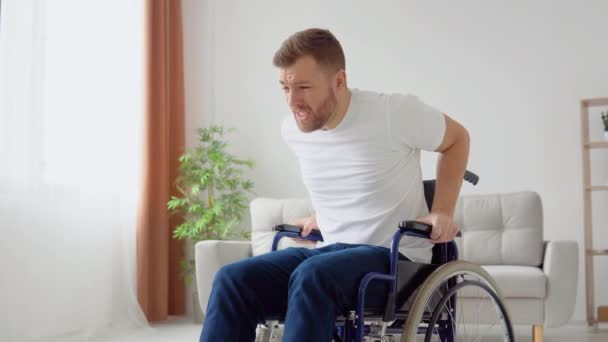 Triste disabile tenta senza successo di alzarsi da una sedia a rotelle. Handicapped non può alzarsi da una sedia a rotelle e picchia le gambe per disperazione — Video Stock