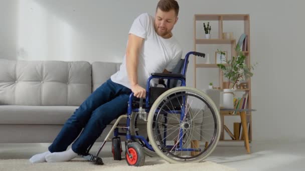 Людина з обмеженими можливостями потрапляє в інвалідне крісло з дивана — стокове відео