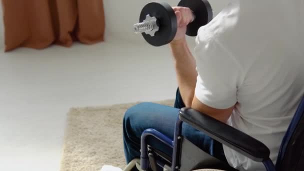 Спортсмен-инвалид в инвалидной коляске выполняет упражнения с зонтиками, домашней тренировкой и физической активностью — стоковое видео