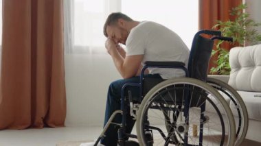 Üzgün engelli bir adam tekerlekli sandalyede oturur ve umutsuzca ağlar. Engelli konsepti