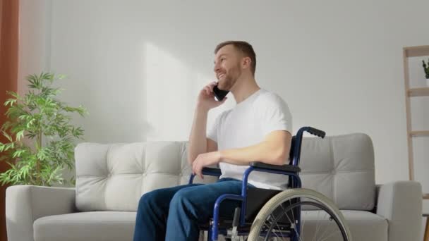 Glücklicher Behinderter sitzt im Rollstuhl und telefoniert — Stockvideo