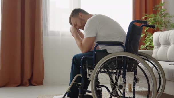 Ο θλιμμένος ανάπηρος κάθεται σε αναπηρική καρέκλα και κλαίει απελπισμένος. Έννοια αναπηρίας — Αρχείο Βίντεο