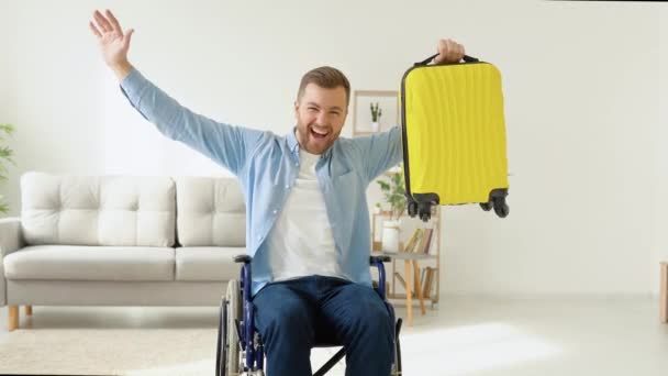 손에 노란 여행 가방을 들고 휠체어를 타고 있는 행복 한 신체 장애자는 여행을 준비하고 있다. 포함 과 신체 장애에 대한 개념 — 비디오