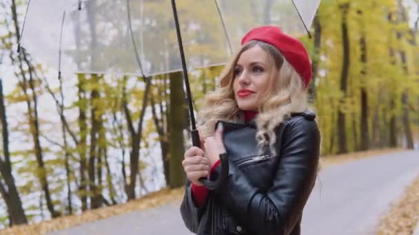 Beautiful young woman coughs standing by an umbrella on a cold autumn day. Seasonal illnesses, cough, cold — Stock Video