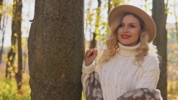 秋の公園の茶色の帽子の笑顔の幸せな陽気な女性の肖像画 — ストック動画