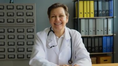 Kıdemli bayan doktor çevrimiçi video görüşmesi yapıyor. Kafkasyalı kadın terapist uzaktan sohbette kamerayla konuşuyor.