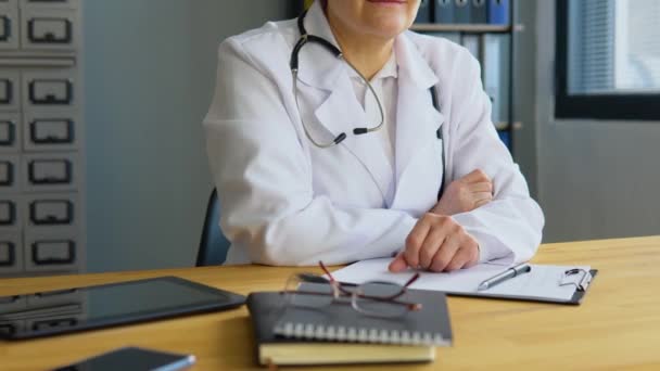 Gros plan d'une femme médecin chevronnée assise dans son bureau — Video