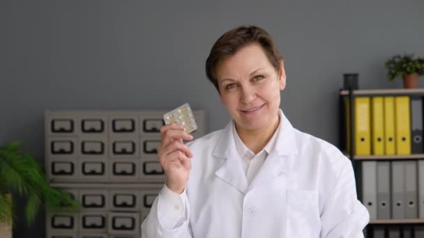 Портрет старшої жінки-лікаря 50х з таблетками — стокове відео