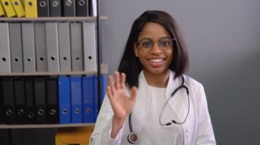 Genç Hintli bayan doktor çevrimiçi video görüşmesi yapıyor. Kadın terapist kamerayla uzaktan sohbet ederek video konferans yapıyor.