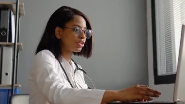 Kadın terapist kamerayla uzaktan sohbet ederek video konferans yapıyor. Genç Hintli kadın doktor çevrimiçi video görüşmesi yaptı.