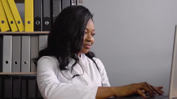 Genç Afrikalı kadın doktor dizüstü bilgisayarla çalışıyor. — Stok video