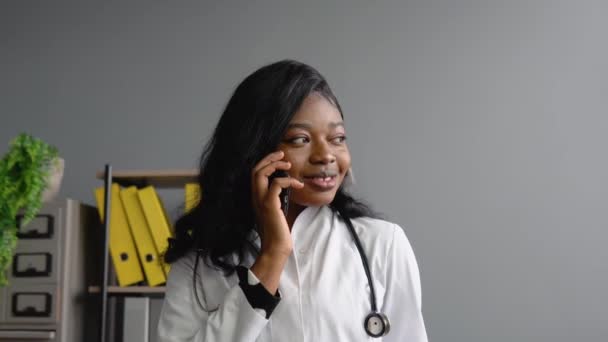 Young african woman doctor consultpatient by phone — Stock Video