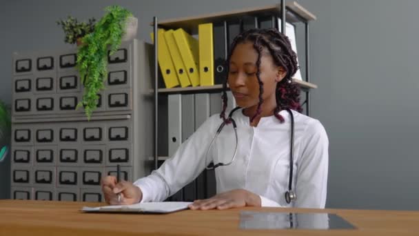 Jovem médica africana escreve história de doença do paciente — Vídeo de Stock