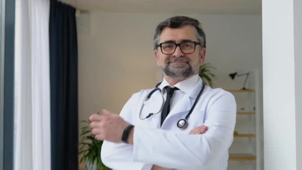 Allegro medico anziano in tuta bianca con braccia incrociate e stetoscopio — Video Stock