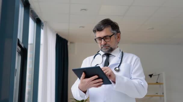 Médico Sênior 50s trabalha em tablet — Vídeo de Stock