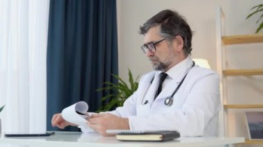 Deneyimli doktor 50 'li yaşlarda hastaların tıbbi geçmişini inceliyor.