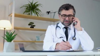 Kıdemli doktor hastaya telefonla danıştı. Ofiste çalışan yaşlı bir terapist.
