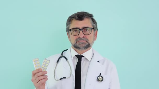 Consulente medico farmacista senior che mostra due confezioni di pillole e sorride con la macchina fotografica. Concetto di medicina e sanità, educazione medica, settore farmaceutico — Video Stock