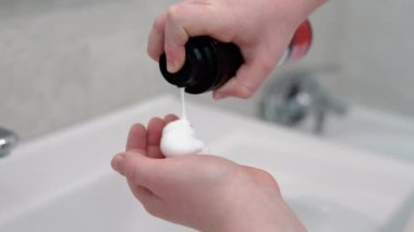 Küçük çocuk banyoda tıraş köpüğü sürüyor.